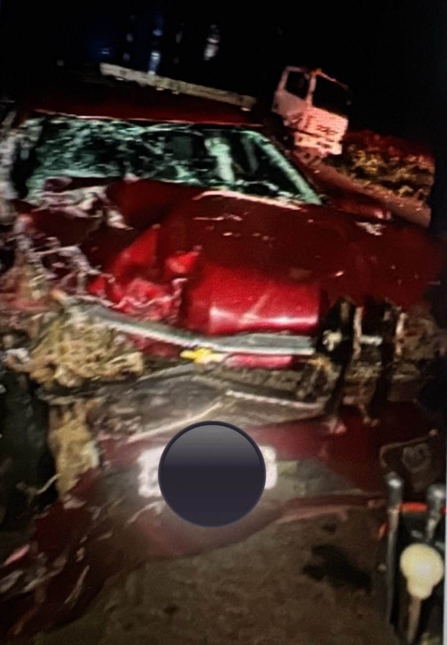 Automóvel vermelho com a parte dianteira destruída após colisão frontal com um caminhão durante a noite na PR-170, em Pinhão.