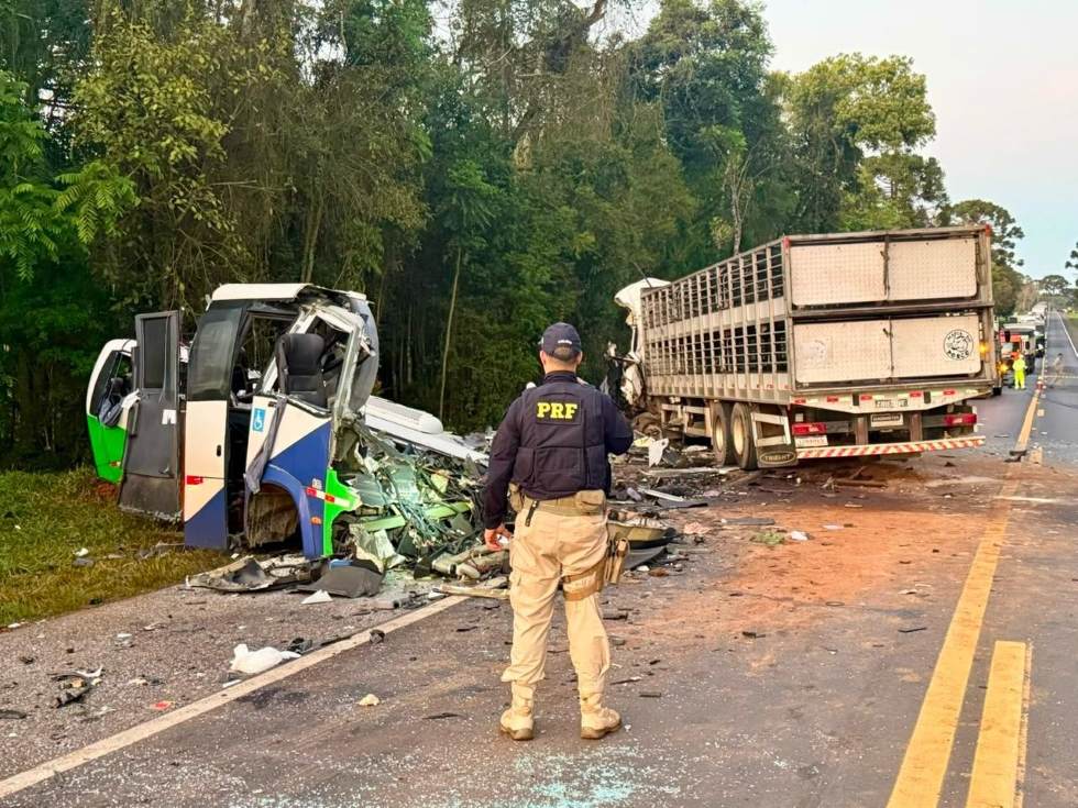 Agente da PRF observa os destroços de um ônibus e de um caminhão após colisão frontal na BR-373, em Ipiranga, no Paraná.
